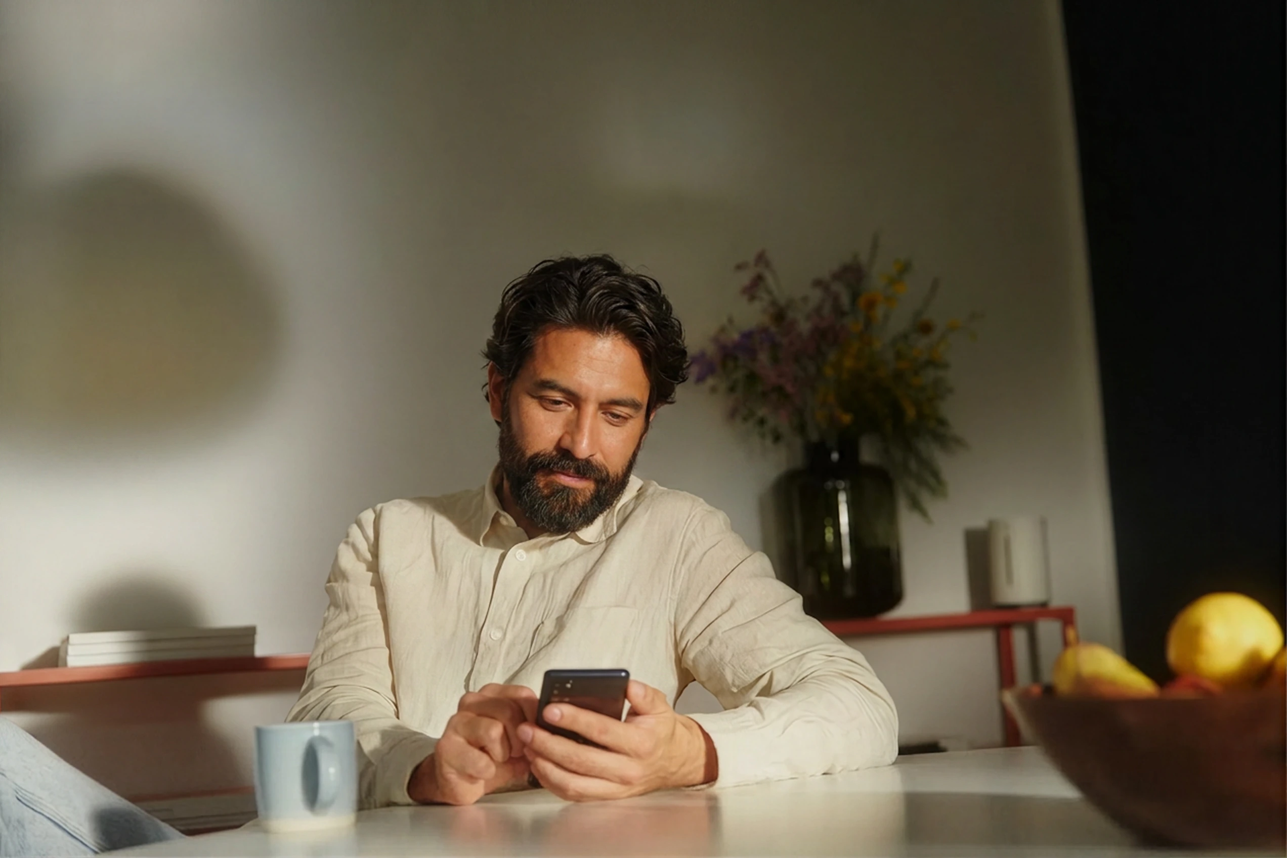 A man at home with his phone, the members who get better outcomes with a fully digital coach.